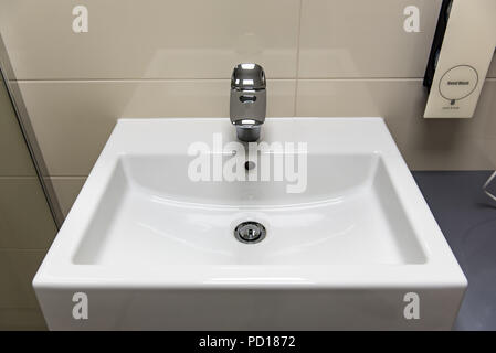 Classic modern white washbasins with chrome water tap and soap holder Stock Photo