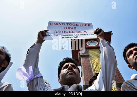 Srinagar, India. 5 August 2018. A member of Kashmir Traders and Manufactures Federation (KTMF) seen holding a placard during the protest.Life in Kashmir valley came to a standstill due to a complete shutdown called by the Joint Resistance Leadership (JRL) against the legal challenge in the Supreme Court on the validity of Article 35-A, which bars people from outside Jammu and Kashmir from acquiring any immovable property in the state. Traders staged a sit-down at the historic clock tower in Lal Chowk to protest the ''legal onslaught'' on the Article 35-A. Protestors carrying placards Credit: Z Stock Photo