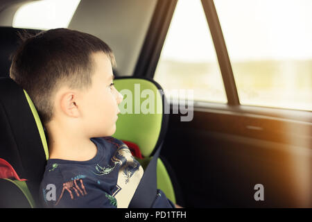 Portrait of pretty toddler boy sitting in car seat. Child transportation safety Stock Photo