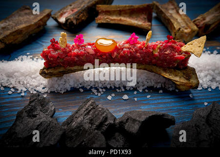 Steak tartar with egg yolk on half bone presentation modern cuisine Stock Photo