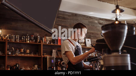 a serious shop assistant is offering different kinds of coffee. side view photo. Stock Photo