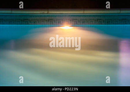 Beautiful blue liner swimming pool by night. Underwater lighting system device fixture. Backdrop with copy space. Stock Photo
