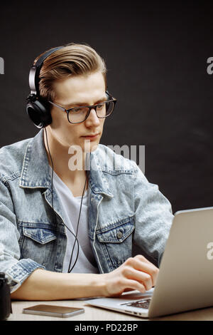 serious rewriter in denim jacket working with computer Stock Photo