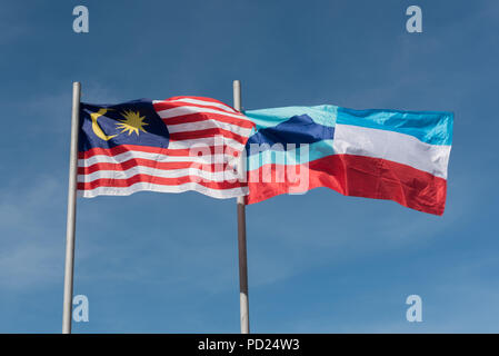 Malaysia and Sabah flag waving in the wind against a blue sky. Stock Photo