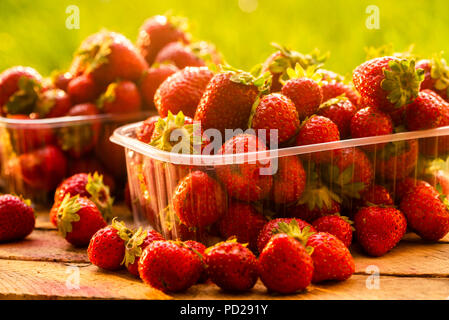 fresh strawberries on a wooden box for sale in plastic boxes, shot close-up Stock Photo
