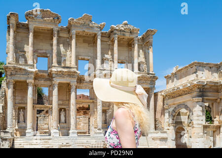 Blonde woman with hat looking at Celsus library in Ephesus, Izmir, Turkey Stock Photo