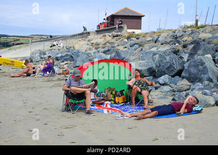 Family relaxing on the beach at Marazion, Cornwall, UK - John Gollop Stock Photo