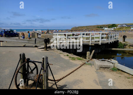 Bude, Cornwall, UK. Holidaymakers enjoy the hot weather walking along the Bude canal and crossing the Sea lock Stock Photo