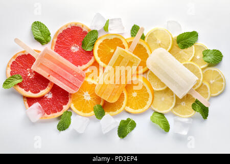 Fruit orange ice lolly, ice cubes and slices of orange on light blue background. Top view. Stock Photo