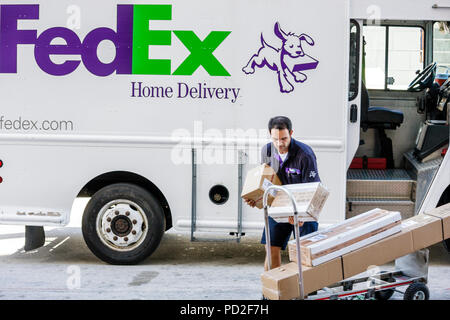 Miami Beach Florida,FedEx,worldwide,company,shipping,Hispanic ethnic man men male adult adults,worker,workers,courier,truck,driver,hand truck cart,dol Stock Photo