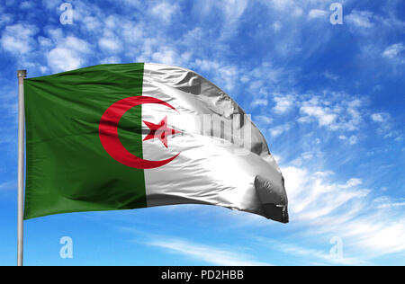 National flag of Algeria on a flagpole in front of blue sky. Stock Photo