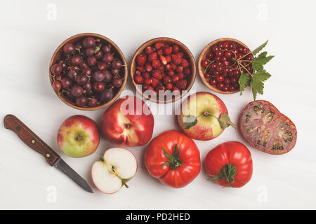 Assortment of red foods on a white background, top view. Fruits and vegetables containing lycopene. Healthy vegan food background. Stock Photo