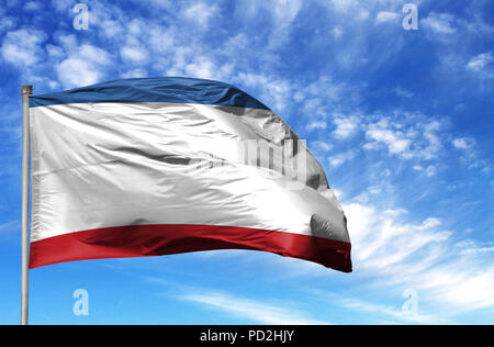National flag of Crimea on a flagpole in front of blue sky. Stock Photo