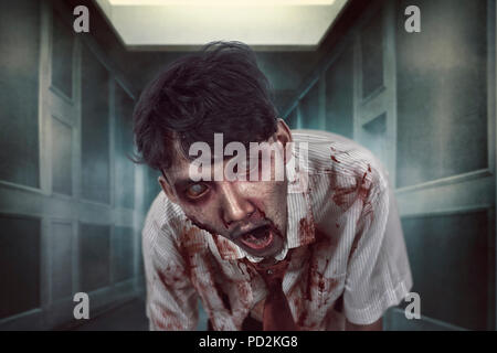 Spooky zombie man with bloody face on the dark place. Halloween concept Stock Photo