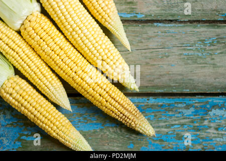 Cobs of fresh sweet corn on a wooden surface. Selective focus. Stock Photo