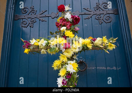 Wooden Easter Cross Decorated With Flowers Outside Church Door