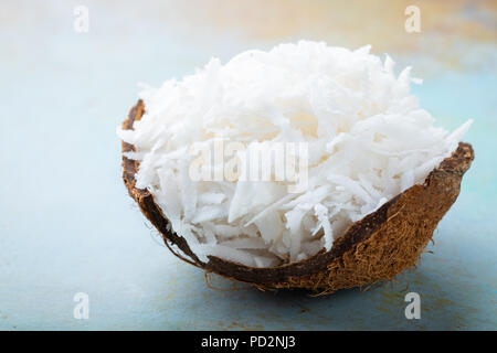 Coconut flakes in a shell on a blue background. Stock Photo