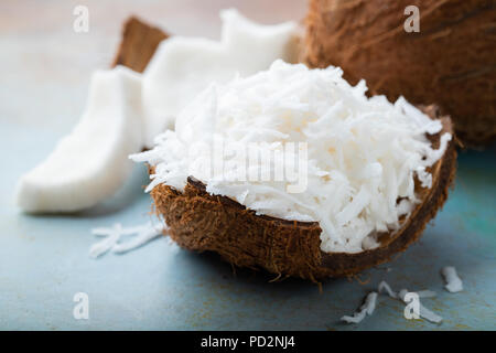 Coconut flakes in a shell on a blue background. Stock Photo