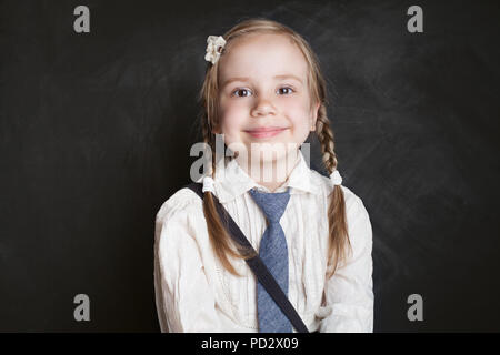 Smiling girl portrait. Happy child schoolgirl on blackboard background Stock Photo