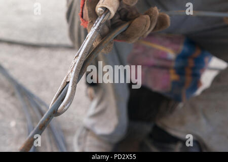 construction worker hands straightens the metal rod. candid, real people Stock Photo
