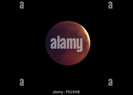 Super Bloody Moon, first phase of full eclipse against black sky background Stock Photo