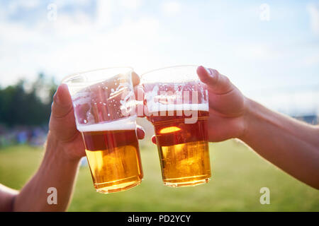 Two young male friends making a toast with glasses of beer at Holi Festival Stock Photo