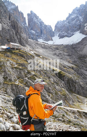 Hiker reading map, Canazei, Trentino-Alto Adige, Italy Stock Photo