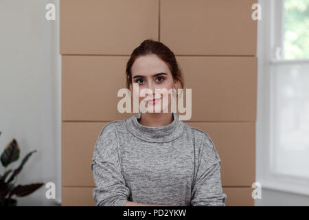 Woman with cardboard boxes in background Stock Photo