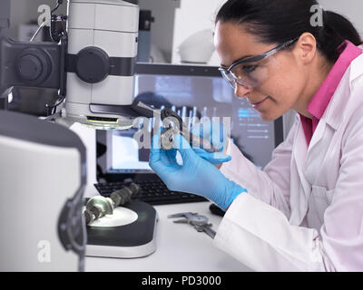 Engineer measuring manufactured component for accuracy and quality control Stock Photo