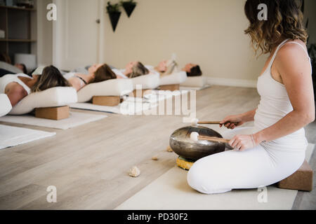 Women in relaxation pose after yoga class at retreat Stock Photo