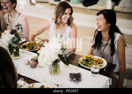 Women enjoying friendship and meal in yoga retreat Stock Photo