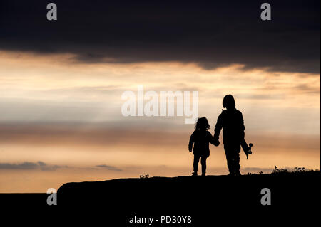 Brother and sister, walking hand in hand, at sunset, Doolin, Clare, Ireland Stock Photo