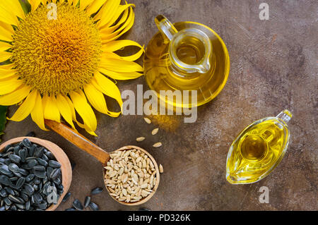 Golden organic oil in a small glass jug, sunflower, sunflower seeds. Agriculture, oil production. Bio and organic concept of the product. Stock Photo