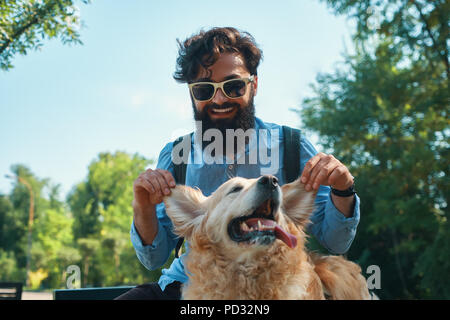 Man and dog having fun, playing, making funny faces while restin Stock Photo