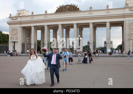 Moscow, Russia. 04th Aug, 2018. A wedding couple stands in front of the main entrance of Gorki Park. The operators of Moscow's world-famous Gorky Park intend to continue adhering to Soviet traditions. The 'Park of Culture and Recreation' was first opened to the public on 12 August 1928. Credit: Emile Ducke/dpa/Alamy Live News Stock Photo