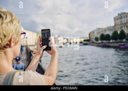 Anonymous woman taking picture on embankment Stock Photo