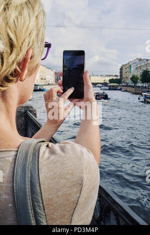 Anonymous woman taking picture on embankment Stock Photo