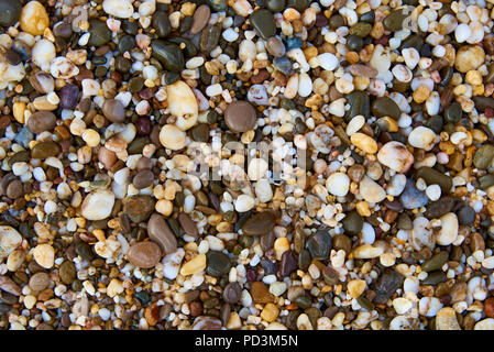 Background texture of wet multicolored stones on the beach. Stock Photo