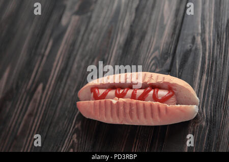 hotdog with tomato sauce on dark wooden background.photo with copy space Stock Photo