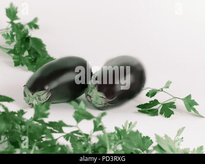closeup.eggplants and sprigs of parsley isolated on white backgr Stock Photo