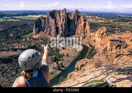 Rock climber pointing at rock formation, Smith Rock State Park, Terrebonne, Oregon, United States Stock Photo