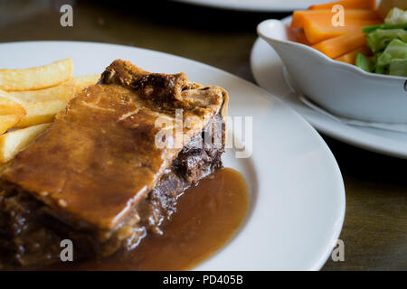 Meat pie with shortcrust pastry, chips and vegetables Stock Photo