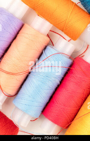 An overhead closeup photo of vibrant sewing thread spools Stock Photo