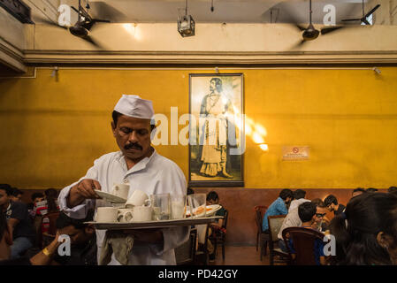 Man bussing tables in the historic Indian Coffee House, College Street, Kolkata, India Stock Photo