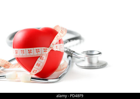 Measuring tape around red heart and stethoscope isolated on white background, health care and diet concept Stock Photo