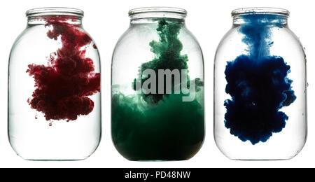 RGB paint swirling in water. Splashes of paint in a glass jar. Stock Photo