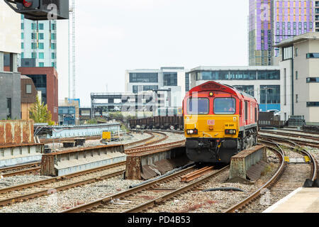 Deutsche Bahn (DB) Cargo Class 66 diesel locomotive number 86 044, hauling goods through Cardiff Central Station. Stock Photo