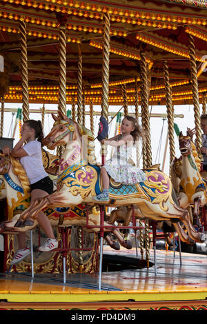 Children on a Steam Galloping horse carousel, fairground ride at a steam fair. England Stock Photo