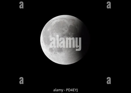Super Bloody Moon, full eclipse last phase against black sky background, quarter of the Moon surface covered by Earth's shadow Stock Photo