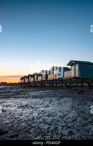 Osea minimalist Beach huts in England modelled on huts in Maldives captured at sunset in summer on secluded beach at low tide Blackwater Estuary Stock Photo